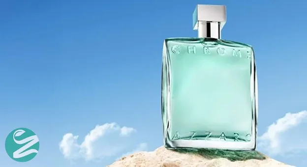 Chrome Azzaro perfume bottle with a light blue liquid placed on a rock against a clear blue sky