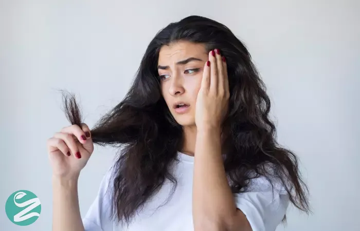 Woman looks at her dry hair